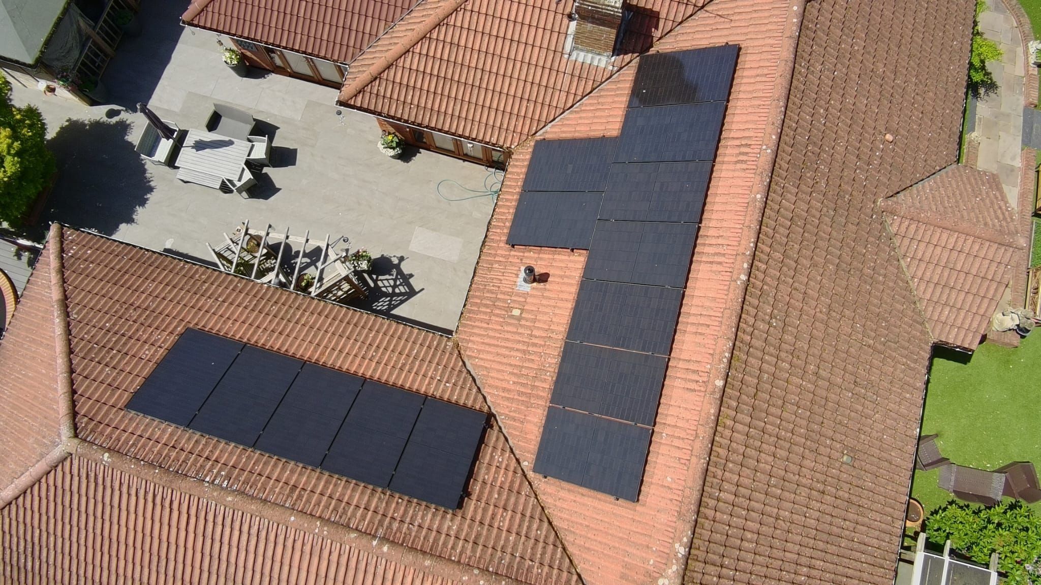 Aerial view of a courtyard bungalow with all-black arrays on several roof slopes