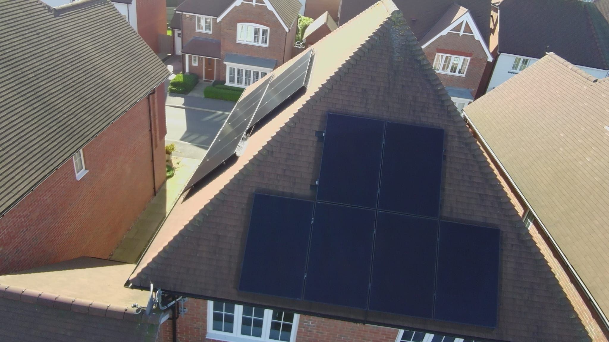 An all-black array on a tiled gable roof, seen from above