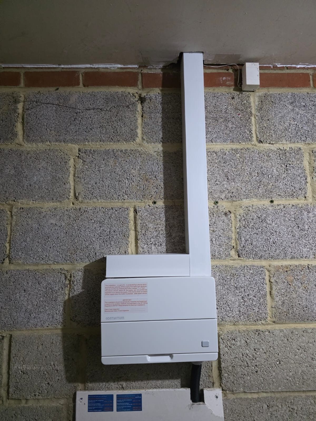 The same consumer unit finished, cover on and its cables run in white trunking