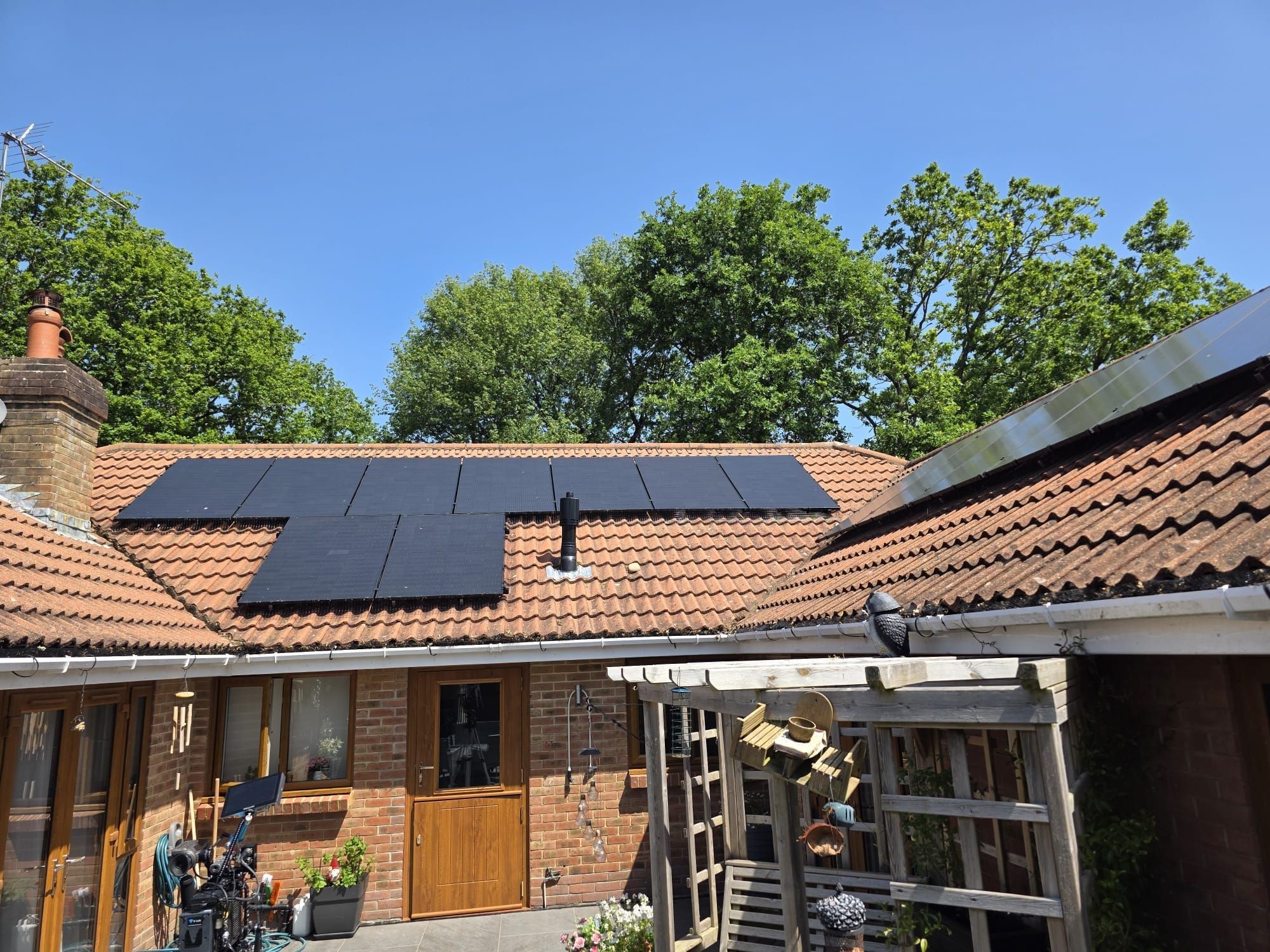 An all-black array on a clay-tiled roof above a courtyard