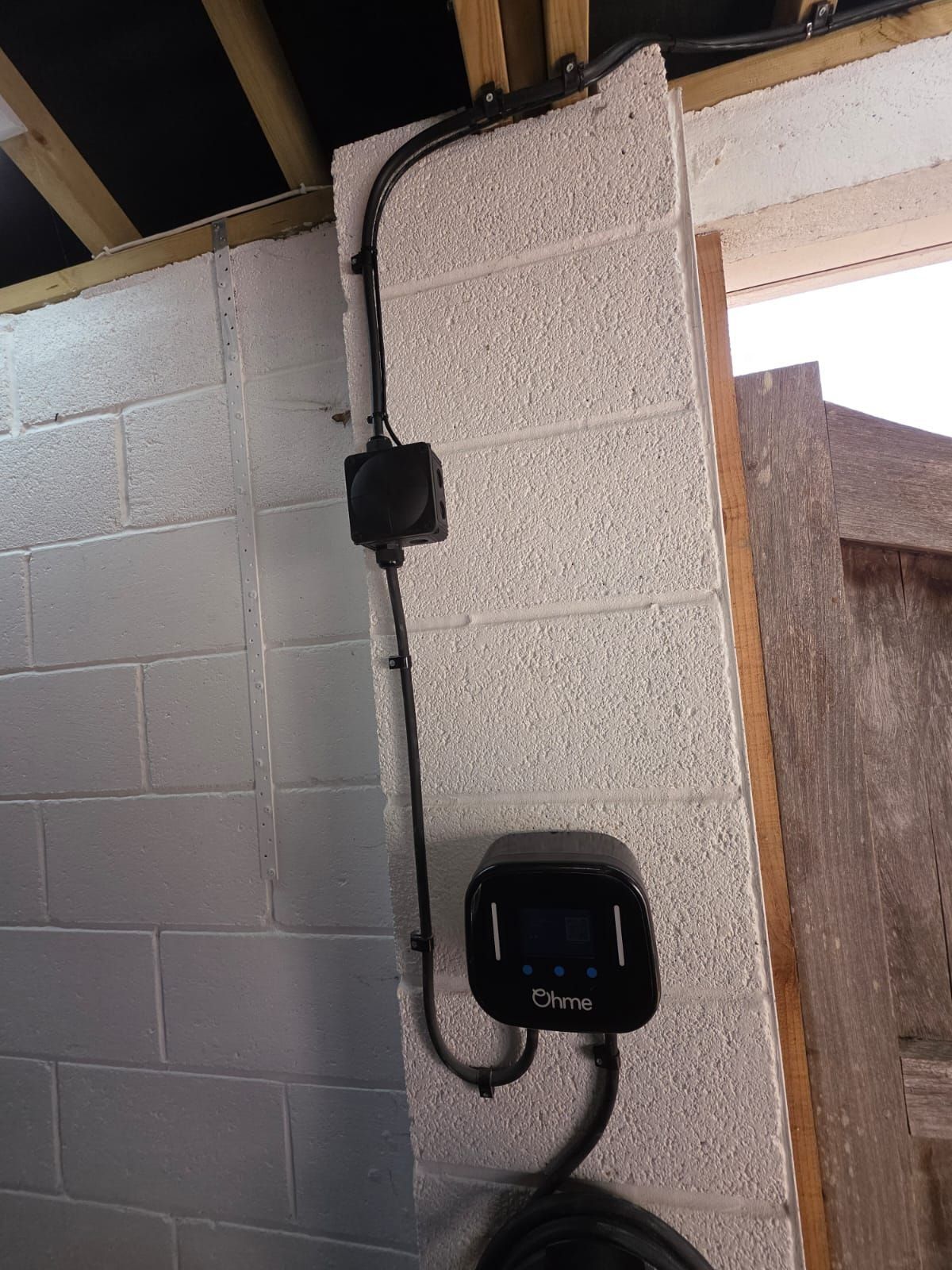 A home EV charger fitted in a carport