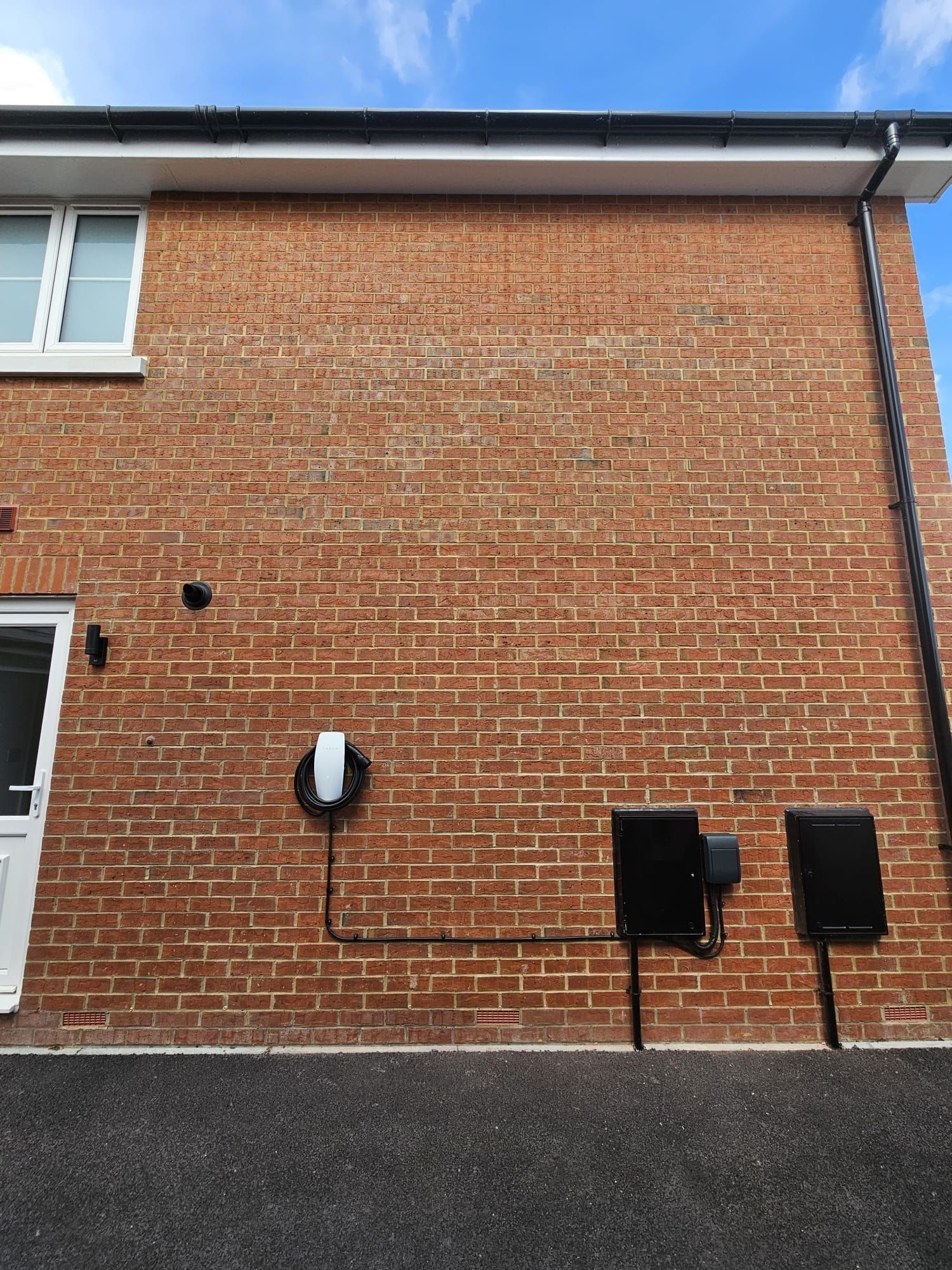 An EV charger on the gable wall of a new-build house