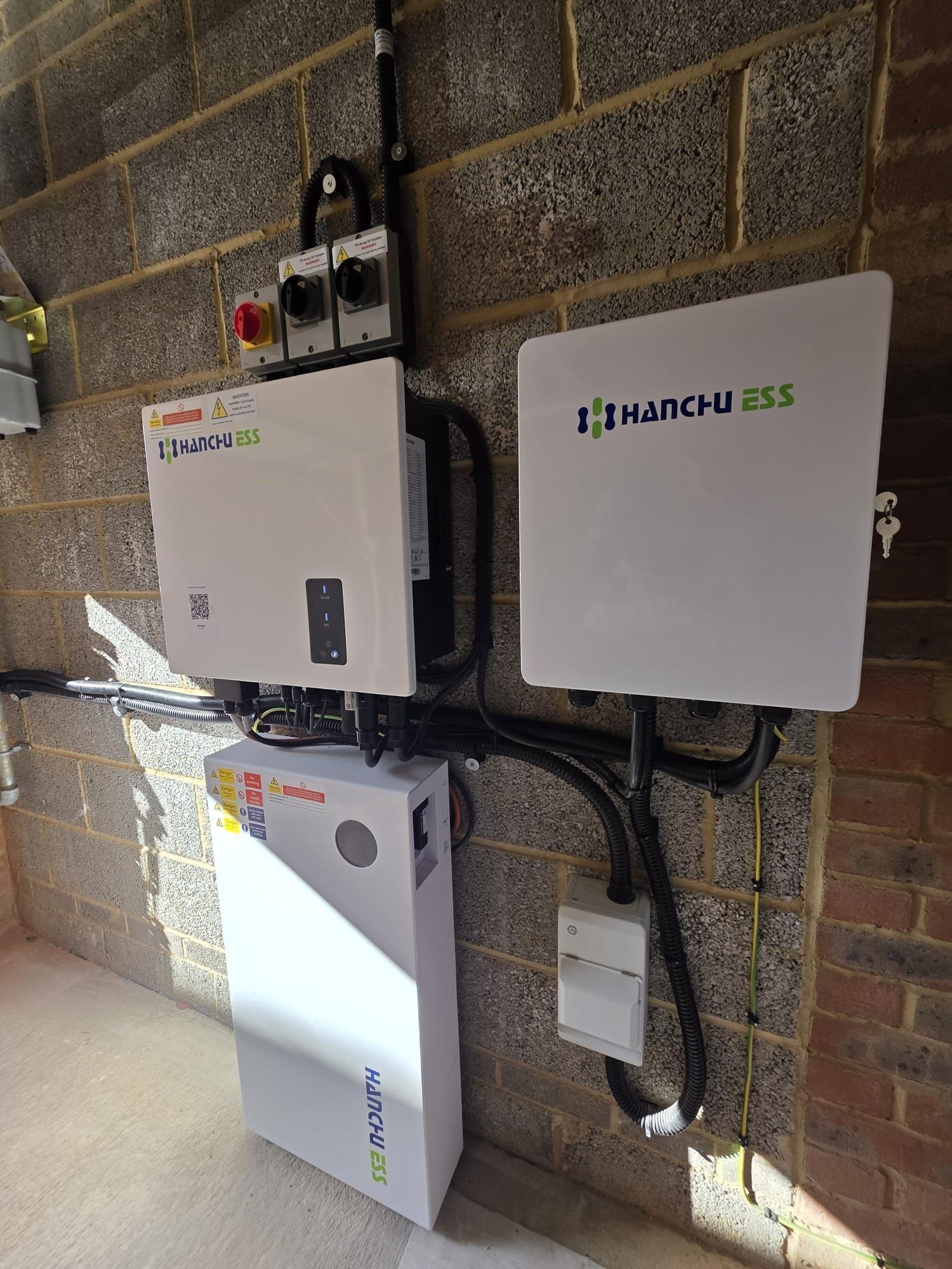A Hanchu ESS hybrid inverter, gateway and battery installed on one wall