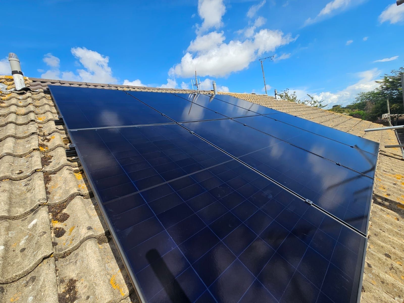 All-black panels on a tiled roof against a blue sky